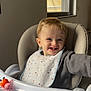 toddler, child, high_chair, smiling, bib, toy, window, indoor, face, sweater, tray, plastic, light, coca_cola_sign, happy, person, cute, young_child, furniture, plaything