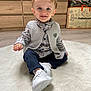 Eden a rejoint le concours — aidez-le/la à gagner de superbes lots ! toddler, child, smiling, indoor, plaid_shirt, knitted_vest, white_shoes, blue_eyes, carpet, home_interior, furniture, drawer, floor, clothing, person, portrait, cute, baby, sitting, young_child