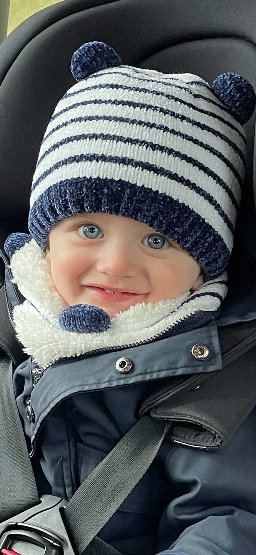 Eden a rejoint le concours — aidez-le/la à gagner de superbes lots ! toddler, child, smiling, hat, knit_hat, striped_hat, bear_ears, scarf, coat, car_seat, seatbelt, blue_eyes, winter_clothing, cute, portrait, face, baby, warm_clothes, closeup, happy