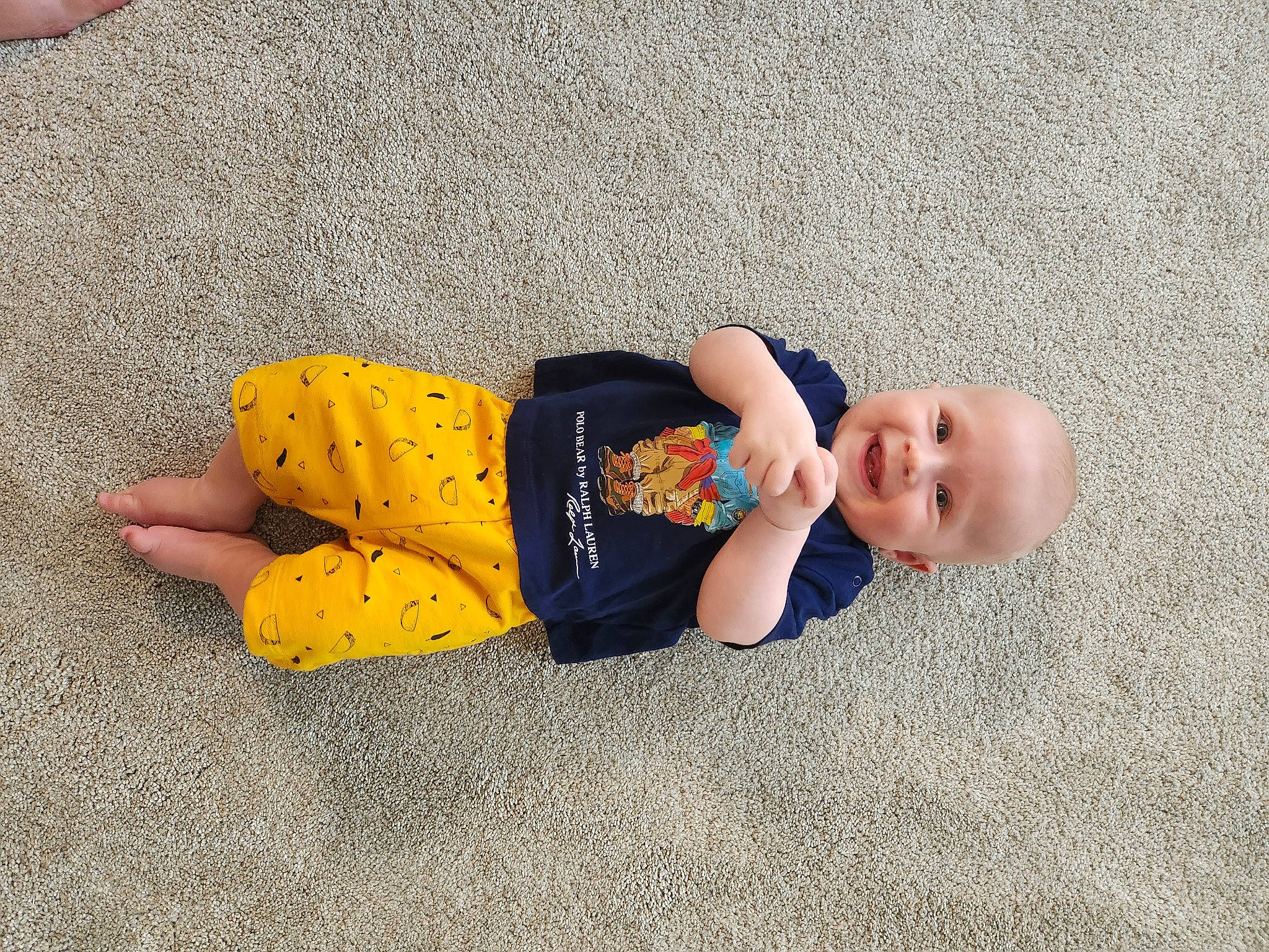 Darius is registered to the contest to win money with this photo: asphalt, baby, baby_toddler_clothing, child, comfort, concrete, eye, face, floor, flooring, fun, grass, head, joy, person, plant, road_surface, sidewalk, sitting, smile