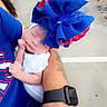 Crystal joined the competition — help win amazing prizes! baby, sleeping, headwear, blue, red, adult_arm, tattoo, smartwatch, crowd, outdoor, pavement, people, walking, casual_clothing, child, infant, holding, portrait, colorful, event