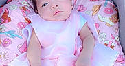 Crystal is registered to the contest to win money with this photo: baby, infant, pink_dress, cushion, floral_pattern, stroller, heart_emoji, cute, child, portrait, indoors, soft_lighting, sleepy, small_hands, clothing, head, face, newborn, resting, comfort