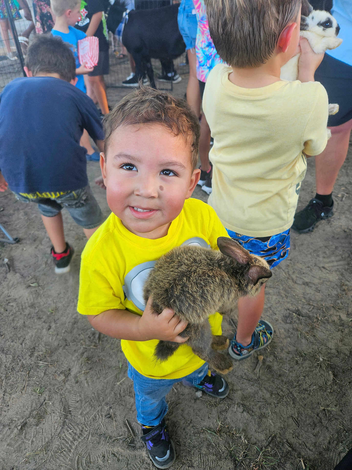 Diego Alessandro joined the competition — help win amazing prizes! child, boy, bunny, animal, pet, yellow_shirt, outdoor, dirt_ground, people, casual_clothing, shorts, sneakers, cute, happy, smiling, crowd, festival, family, fun, summer
