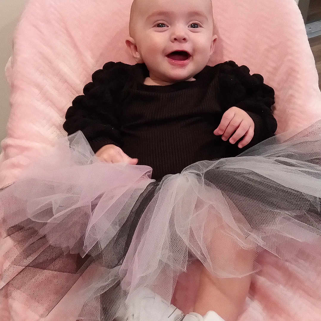 Taylor joined the competition — help win amazing prizes! baby, bodypart, chair, clothing, couch, dress, face, finger, footwear, furniture, hand, head, newborn, pants, person, photography, portrait, shoe, sitting, sneaker