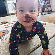 Yzayah participe au concours pour gagner de l'argent avec cette photo : carpet, child, chocolate, crawling, curly_hair, cute, eyes, face_paint, festive_clothing, floor, grinch, hand, holiday_sweater, home, indoor, kitchen, person, playful, smiling, toddler