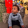 Yzayah a rejoint le concours — aidez-le/la à gagner de superbes lots ! bow_tie, boy, child, christmas_tree, curious, decorations, festive, floor, gift_wrap, holiday, indoor, living_room, pants, portrait, presents, seated, shirt, shoes, socks, toddler