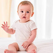 Heipoe Fontaine participe au concours pour gagner de l'argent avec cette photo : baby, bed, child, curious, cute, expression, face, fingers, hand, indoor, infant, onesie, person, portrait, sitting, skin, soft_light, waving, wide_eyes, young