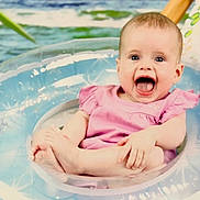 Isabelle is registered to the contest to win money with this photo: baby, infant, smiling, pink_dress, inflatable_ring, water, sitting, happy, child, cute, playful, summer, outdoor, toy, pool, feet, hands, face, joy, expression