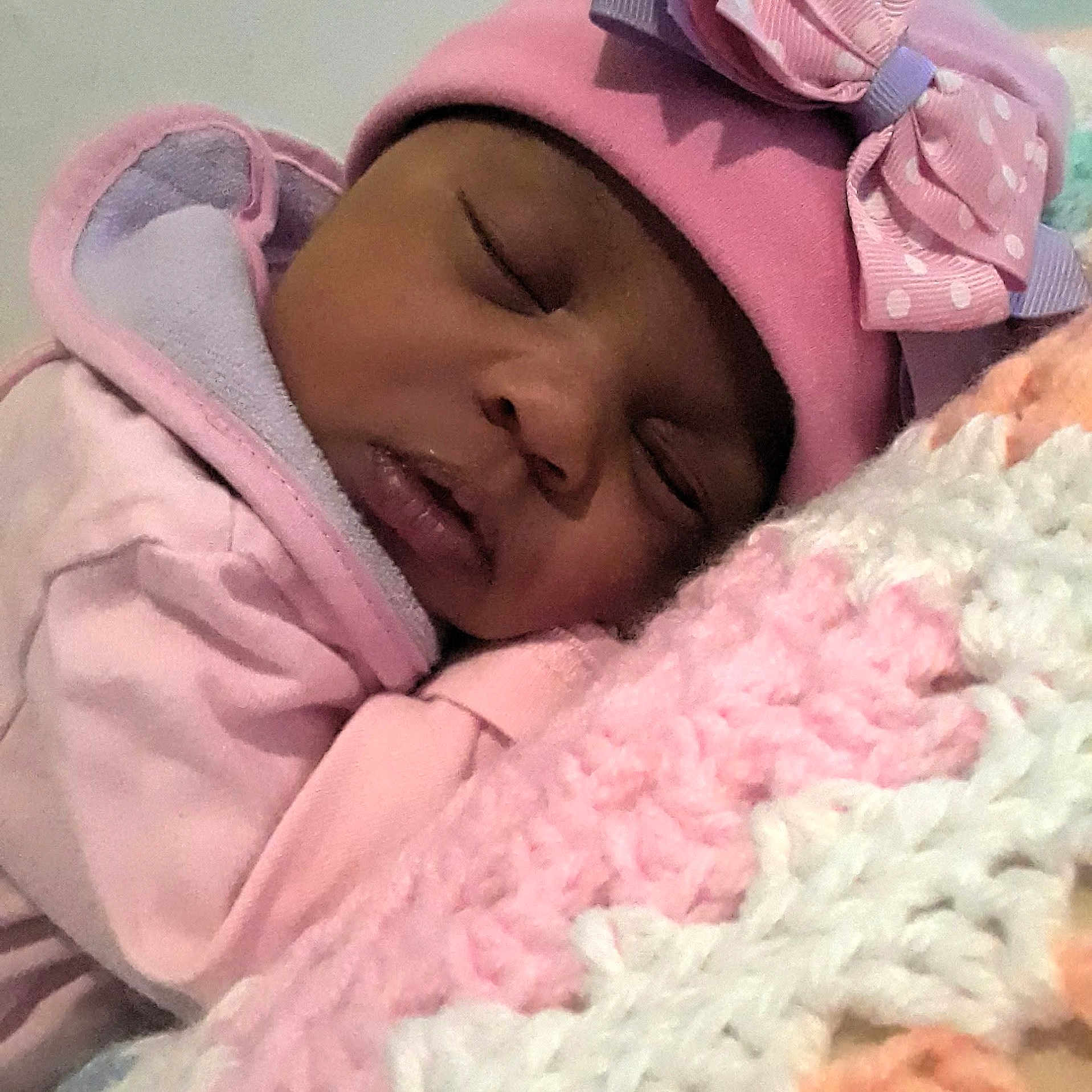 Sharlette joined the competition — help win amazing prizes! baby, sleeping, pink_clothing, hat, bow, blanket, knitted_blanket, closeup, face, child, cozy, soft_texture, indoors, peaceful, resting, cute, portrait, warm, infant, toddler