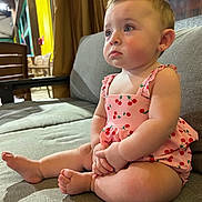 Brianna joined the competition — help win amazing prizes! baby, cherry_pattern, child, couch, cross_legged, curtains, cute, earring, expression, face, feet, furniture, hands, indoor, infant, pink_clothing, portrait, seated, soft_lighting, wooden