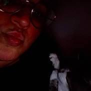 Fils a rejoint le concours — aidez-le/la à gagner de superbes lots ! person, glasses, face, cat, pet, dark, indoor, low_light, close_up, portrait, animal, feline, whiskers, fur, looking_up, companion, friendship, black_background, shadow, casual