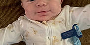 Zayden is registered to the contest to win money with this photo: baby, blanket, blue_tag, brown_background, child, closeup, cushion, cute, duck_print, face, head, indoors, infant, lying_down, newborn, onesie, person, smiling, soft_texture, white_clothing
