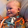 Zayden joined the competition — help win amazing prizes! baby, child, smiling, face, blonde_hair, rosy_cheeks, colorful_clothing, patterned_outfit, indoor, soft_surface, candid, portrait, young_child, happy, person, infant, closeup, cute, relaxed, casual