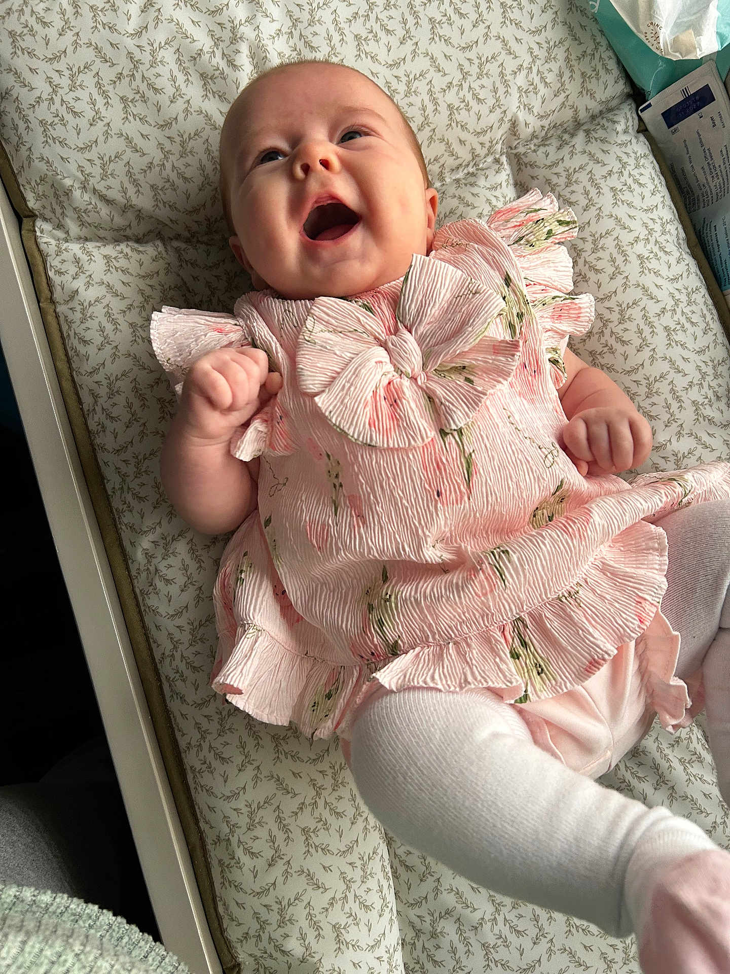 Aiyla joined the competition — help win amazing prizes! baby, infant, smiling, pink_dress, bow, cushion, patterned, lying_down, happy, cute, child, clothing, indoors, person, toddler, white_tights, furniture, closeup, portrait, small_hand