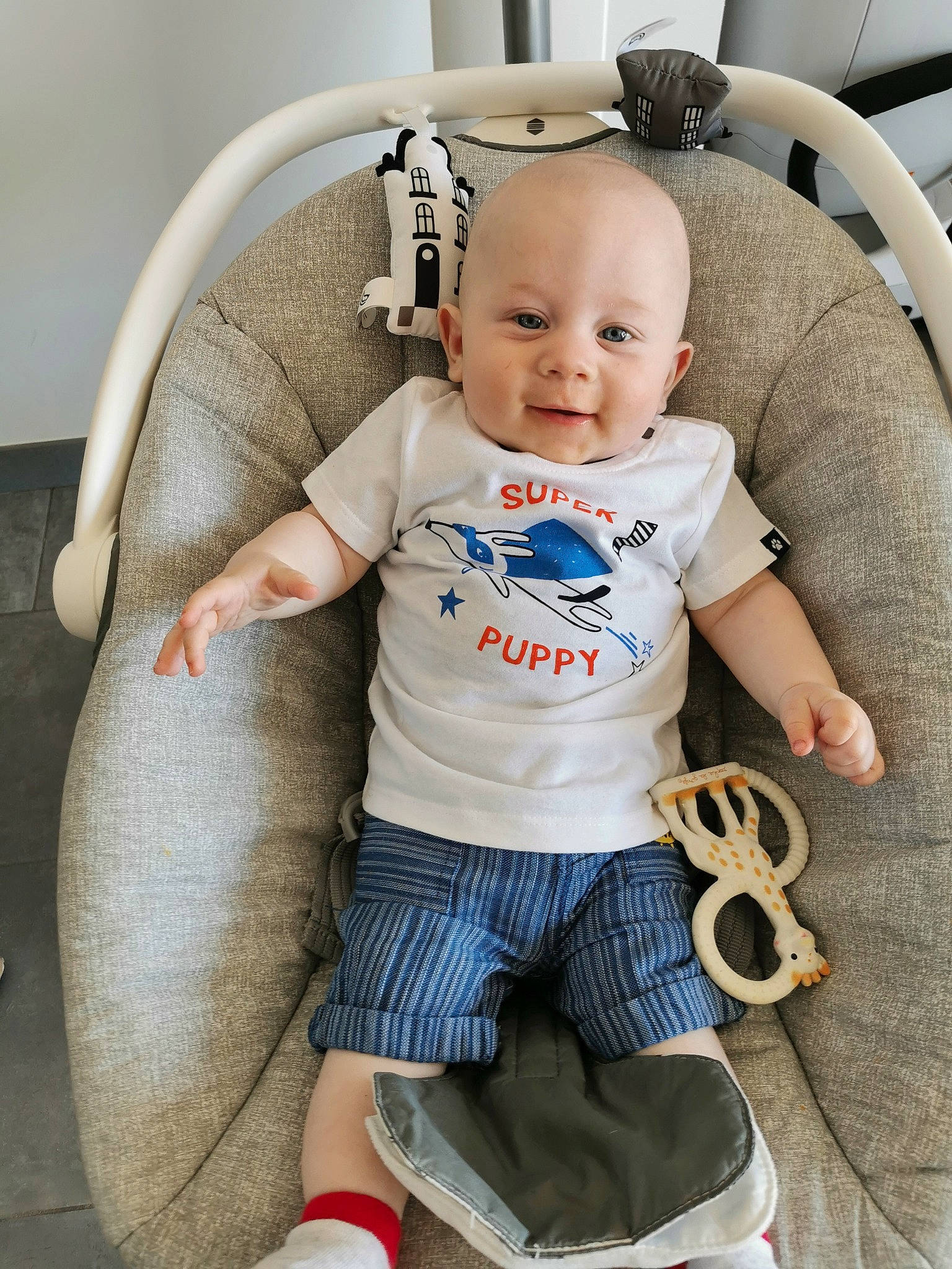 Andréas participe au concours pour gagner de l'argent avec cette photo : arm, baby, baby_carriage, baby_products, baby_safety, baby_toddler_clothing, chair, comfort, cool, electric_blue, finger, happy, knee, leg, person, sleeve, smile, sock, t_shirt, thigh