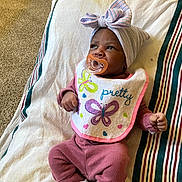 Honesti joined the competition — help win amazing prizes! baby, infant, pacifier, bib, pink_clothing, headwrap, striped_blanket, carpet, lying_down, cute, indoors, child, newborn, socks, cozy, portrait, colorful, patterned, soft, peaceful
