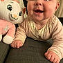 baby, child, smiling, crawling, plush_toy, cat_toy, indoor, couch, person, happy, face, hand, clothing, toy, fabric, background, adult, closeup, portrait, cute