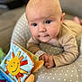 Augustin participe au concours pour gagner de l'argent avec cette photo : baby, blue_eyes, book, child, close_up, clothing, curious, cushion, cute, early_childhood, face, hand, indoor, infant, person, playtime, polka_dot, smiling_sun, soft_toy, toddler