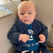 Augustin participe au concours pour gagner de l'argent avec cette photo : baby, blue_clothing, child, closeup, couch, cozy, cute, expression, face, furniture, hands, indoor, infant, knitted_jacket, portrait, sailboat_graphic, sitting, soft_lighting, teal_shirt, young_child