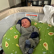 August joined the competition — help win amazing prizes! avocado_pattern, baby, bassinet, blanket, clothing, cushion, door, floor, furniture, hat, indoor, infant, mittens, newborn, resting, shelf, sleeping, sock, storage_boxes, warning_label