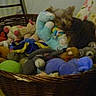 dog, stuffed_toys, wicker_basket, plush, toy, animal, pet, indoor, floor, floral_pattern, cozy, small_dog, brown_dog, resting, cute, collection, soft_toys, home, relaxing, basket
