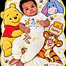 baby, bear, blanket, cartoon_characters, child, clothing, colorful, curly_hair, cute, donkey, foot, infant, lying_down, playful, portrait, smiling, soft_texture, striped_pants, tiger, winnie_the_pooh