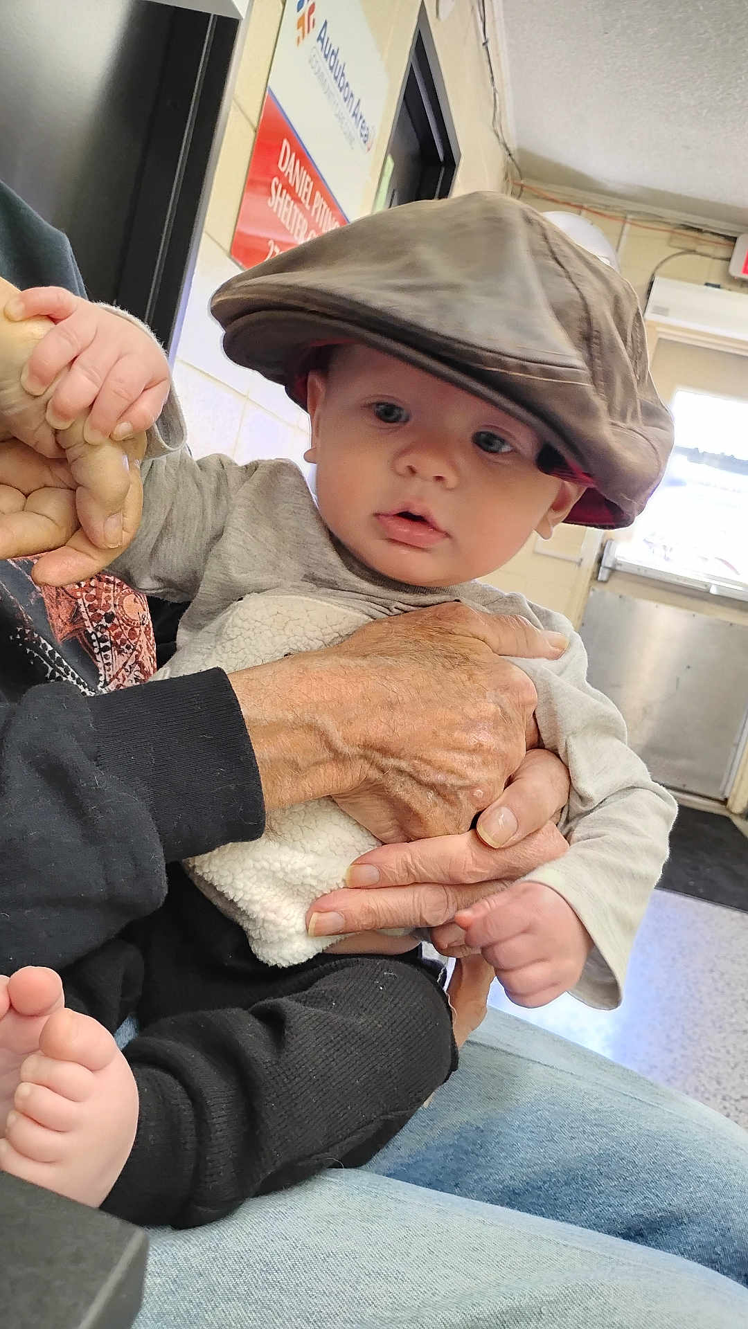Heartley joined the competition — help win amazing prizes! baby, child, hat, cap, hands, indoor, door, sign, clothing, person, foot, jeans, sleeve, holding, expression, skin, face, casual, seated, curious