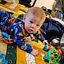 Heartley is registered to the contest to win money with this photo: baby, child, pajamas, toy, quilt, indoor, colorful, face, hand, person, floor, plush_toy, blanket, crawling, infant, home, clothing, curious, blue, orange