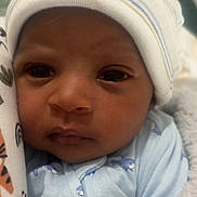 Tayvion Davis is registered to the contest to win money with this photo: baby, newborn, infant, child, portrait, face, eyes, hat, beanie, onesie, blue_clothing, striped_hat, blanket, swaddled, lying_down, indoors, cozy, close_up, looking_at_camera, soft_lighting