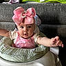 baby, infant, bow, pink, baby_walker, couch, blanket, indoor, child, cute, reaching, clothing, face, person, home, furniture, expression, headwear, sitting, curious