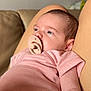 Freya participe au concours pour gagner de l'argent avec cette photo : baby, infant, pacifier, pink_clothing, striped, person, face, skin, arm, lap, couch, indoor, relaxing, young_child, portrait, closeup, human, newborn, calm, soft_lighting
