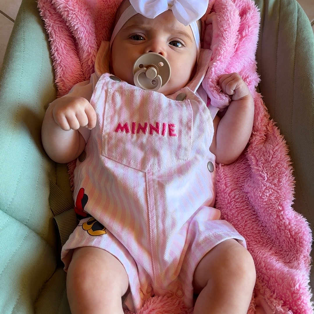Freya participe au concours pour gagner de l'argent avec cette photo : baby, bow, child, comfort, cushion, cute, feet, fist, headband, indoor, infant, legs, minnie, pacifier, pink_blanket, pink_clothing, portrait, seat, soft_texture, toddler