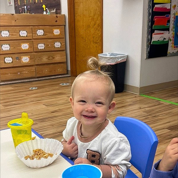 Cove is registered to the contest to win money with this photo: baby, cabinetry, chair, chest, child, comfort_food, drawer, flooring, food, fun, happy, hardwood, joy, person, plate, play, sharing, smile, table, tableware