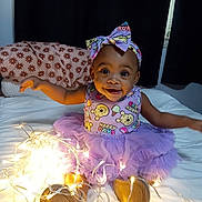 Arys joined the competition — help win amazing prizes! baby, bed, blanket, bow, child, curtains, cute, decor, earrings, fairy_lights, footwear, happy, headband, indoors, lighting, person, pillow, purple_dress, smiling, toddler