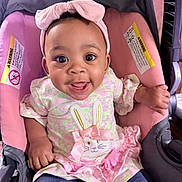 Arys is registered to the contest to win money with this photo: baby, child, infant, smiling, headband, pink, car_seat, cute, happy, dress, bunny, bow, clothing, portrait, toddler, sitting, face, person, indoors, accessory