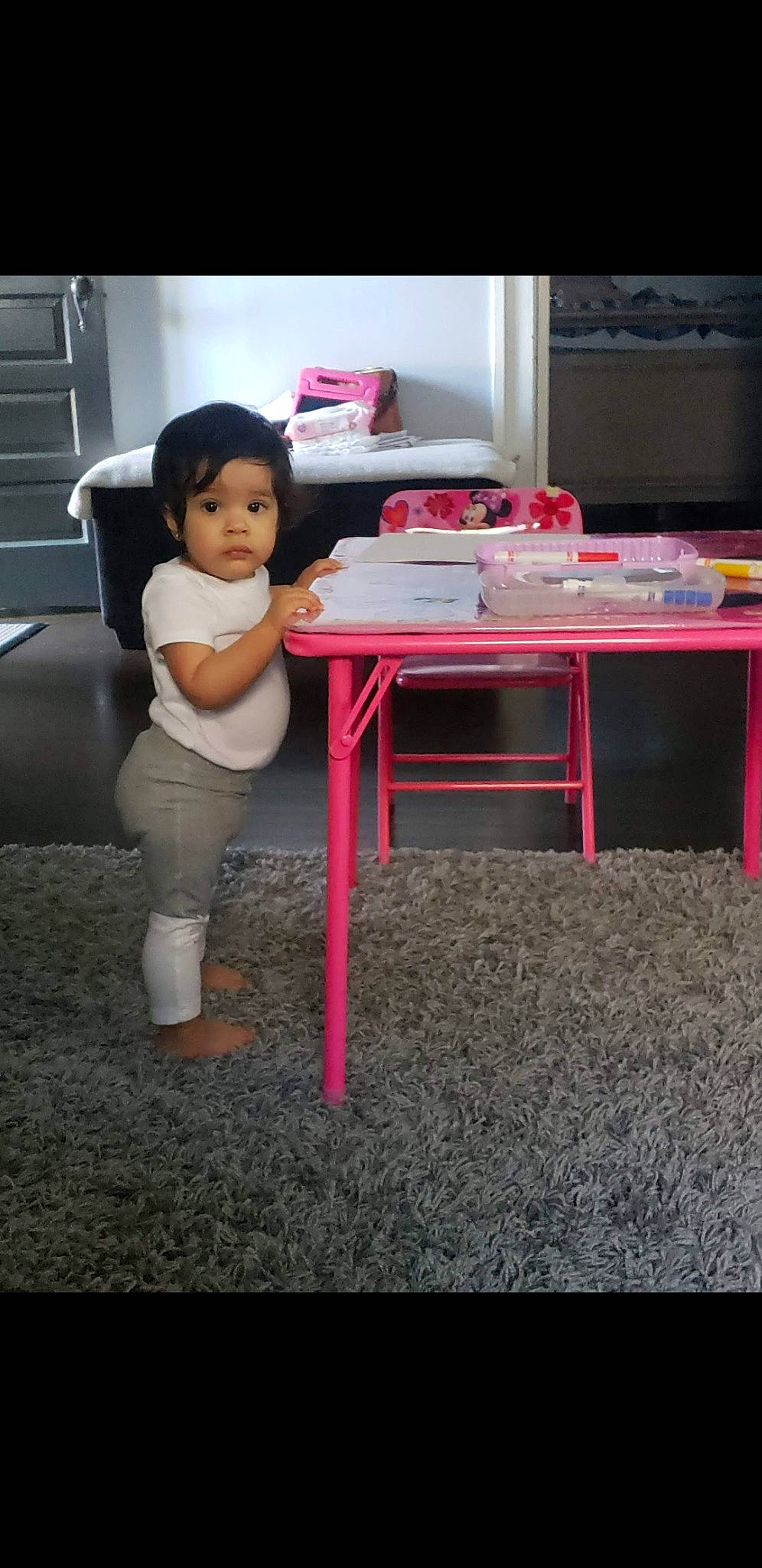 Julissa is registered to the contest to win money with this photo: chair, child, desk, floor, flooring, furniture, material_property, person, pink, play, sitting, standing, table, toddler