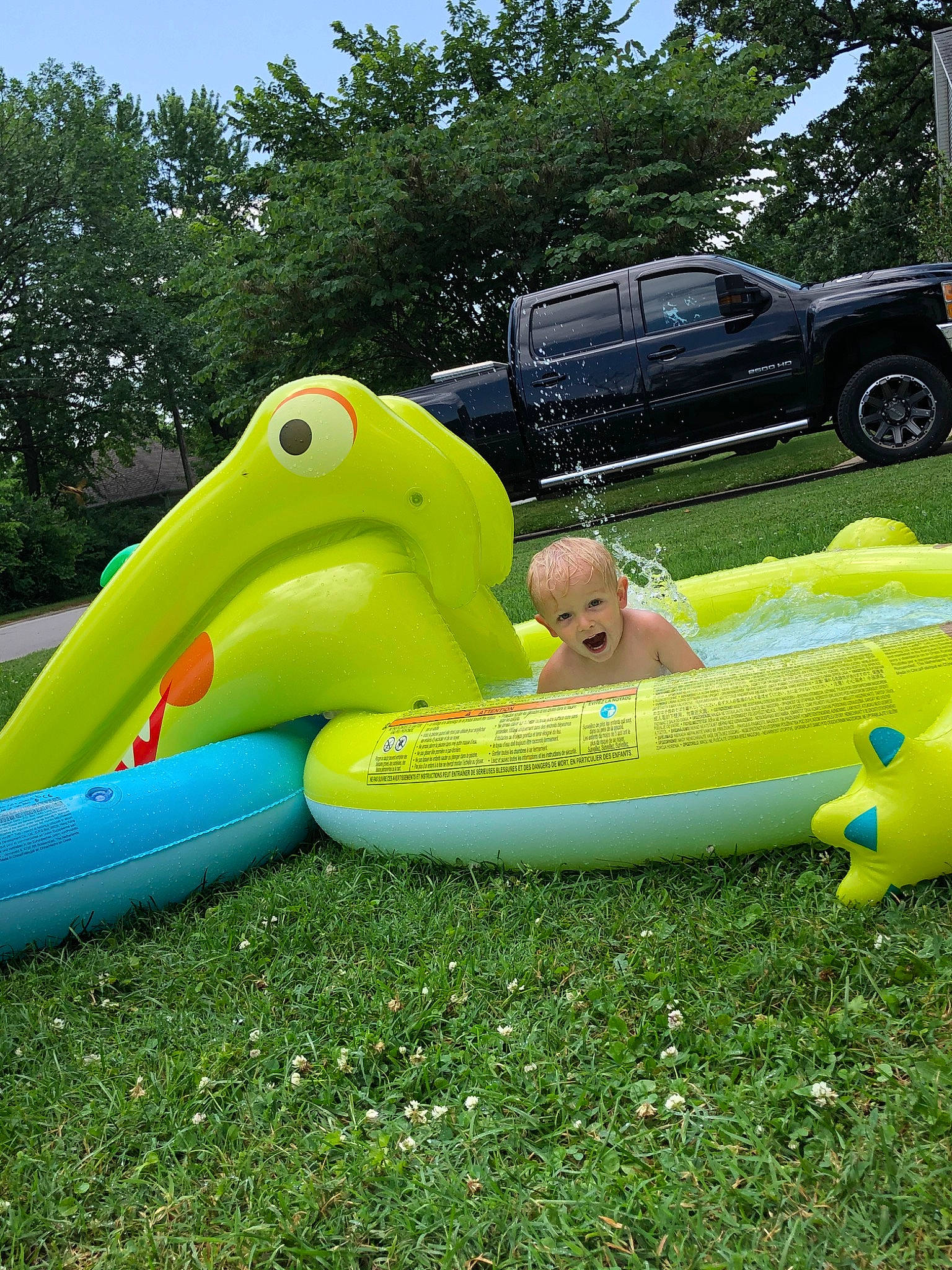 Kristopher joined the competition — help win amazing prizes! baby_float, boats_and_boating_equipment_and_supplies, car, chute, fun, grass, leisure, nature, outdoor_recreation, people_in_nature, person, plant, recreation, sky, tire, toddler, toy, tree, vehicle, water