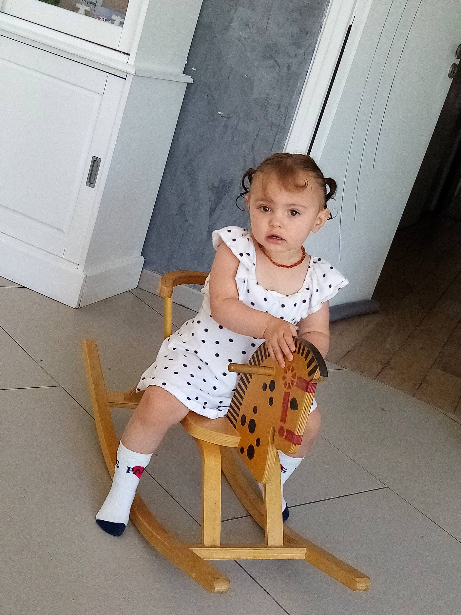 Lena participe au concours pour gagner de l'argent avec cette photo : baby_toddler_clothing, chair, child, door, fawn, floor, flooring, folding_chair, hardwood, human_leg, joint, knee, pattern, person, room, shorts, sitting, standing, thigh, toddler