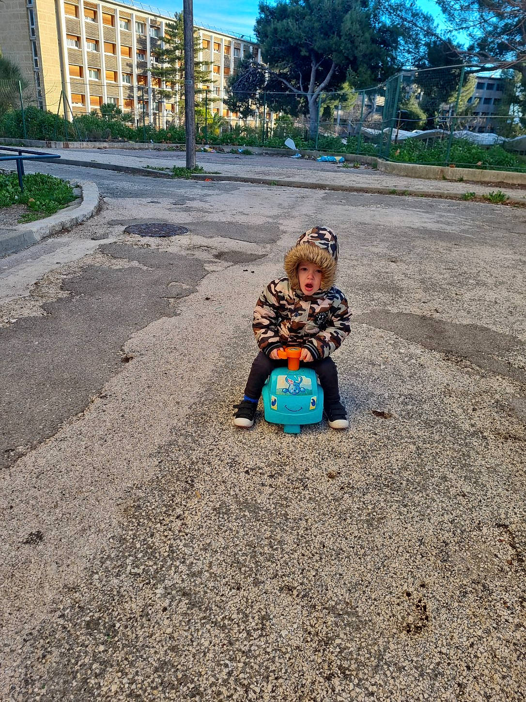 ézéchiel participe au concours pour gagner de l'argent avec cette photo : asphalt, building, city, concrete, fun, grass, headwear, leisure, person, plant, recreation, road, road_surface, rolling, sand, sidewalk, sitting, sky, soil, tar