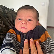 Marius a rejoint le concours — aidez-le/la à gagner de superbes lots ! baby, infant, hand, sweater, striped_clothing, person, face, indoor, portrait, young_child, skin, fingers, knitwear, closeup, warm_clothing, newborn, candid, expression, human, holding