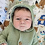 baby, infant, hoodie, knitted, green, face, expressionless, blanket, animal_print, background, cute, child, portrait, indoors, button, hand, fur_ears, soft_lighting, cozy, closeup