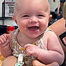adult, arms, baby, background, child, close_up, eyes, face, floral_outfit, held, indoor, infant, laughing, open_mouth, pacifier_clip, people, portrait, sleeveless, smiling, soda_can