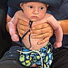 Kolter is registered to the contest to win money with this photo: baby, adult, hat, hand, shorts, sea_creatures, blue, skin, person, holding, wide_eyes, indoor, casual_clothing, cute, infant, portrait, child, smiley_face, support, background