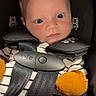 baby, car_seat, child, infant, orange_mittens, striped_clothing, seatbelt, face, head, young_child, person, safety, cute, indoors, portrait, expression, wide_eyes, clothing, seat, baby_carrier