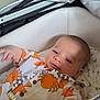 baby, infant, stroller, crab_pattern, clothing, cute, child, face, hand, paciifier, beads, orange, white, gray, indoor, person, newborn, sleeping_bag, toddler, portrait