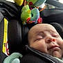 Leo is registered to the contest to win money with this photo: baby, car_seat, infant, sleeping, plush_toys, pacifier, black_fabric, closeup, child, seatbelt, zipper, no_smoking_sign, airbag_warning, comfort, head, face, rest, travel, indoor, soft_toys