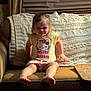 Reese is registered to the contest to win money with this photo: child, girl, smile, sitting, couch, blanket, knitted, hello_kitty, shirt, shorts, barefoot, indoors, curtains, window_blinds, cozy, furniture, living_room, happy, portrait, casual