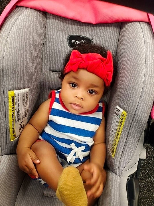 Hailey is registered to the contest to win money with this photo: baby, baby_carriage, baby_products, baby_toddler_clothing, car_seat, chair, child, comfort, electric_blue, fashion_accessory, headwear, magenta, pattern, person, product, sitting, sleeve, textile, thigh, thumb