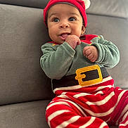 Lyam participe au concours pour gagner de l'argent avec cette photo : baby, child, christmas, couch, cozy, cute, elf_costume, festive, happy, hat, holiday, indoors, infant, person, playful, portrait, red_and_green, smiling, striped_pants, tongue_out