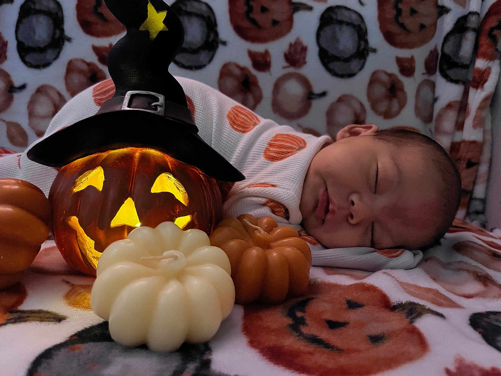 Nani is registered to the contest to win money with this photo: baby, sleeping, pumpkin, jack_o_lantern, witch_hat, blanket, halloween, candle, decor, orange, white, face, infant, cozy, holiday, cute, festive, soft, child, lying_down